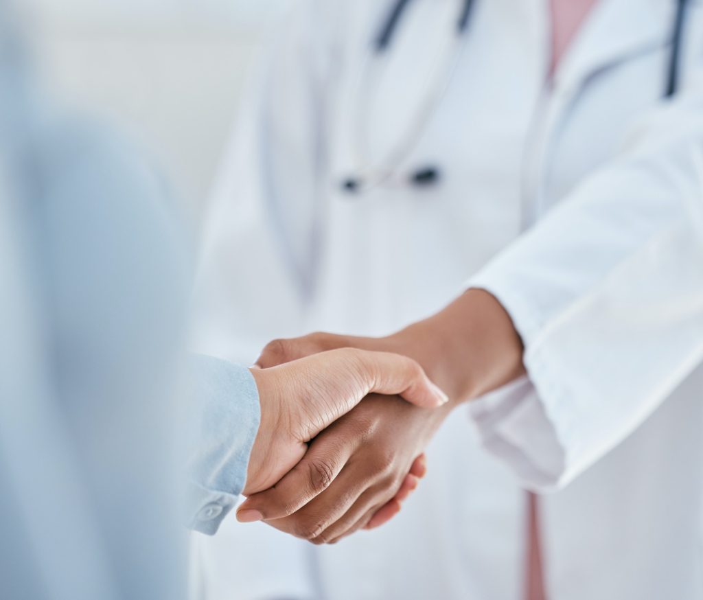 Handshake, trust and thank you with patient and doctor or medical worker shaking hands, greeting or